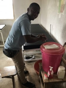 Dr. Sandy Gangha washing his hands at a hand washing station at the MOH clinic in Ngolahun. We have supplied the village with 80 stations like this to prevent the spread of COVID-19.