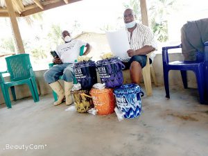 Paramount Chief Baion briefs the sub-chiefs on the distribution of the buckets.