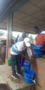 Practicing effective hand washing techniques under the watchful eye of the village leaders.