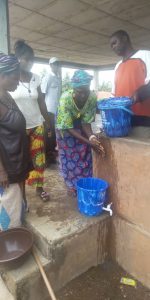 One of the female leaders demonstrating proper hand washing techniques to the village women.