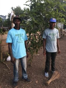 Jusu and MOH volunteer with one of our fastest growing trees