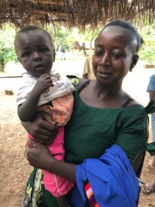 A mother proudly shows the weight gain of her child after completing the Malnutrition Program
